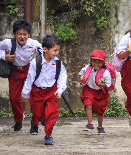 Excited Indonesian primary school kids running cheerful Excited Indonesian primary school kids running cheerful