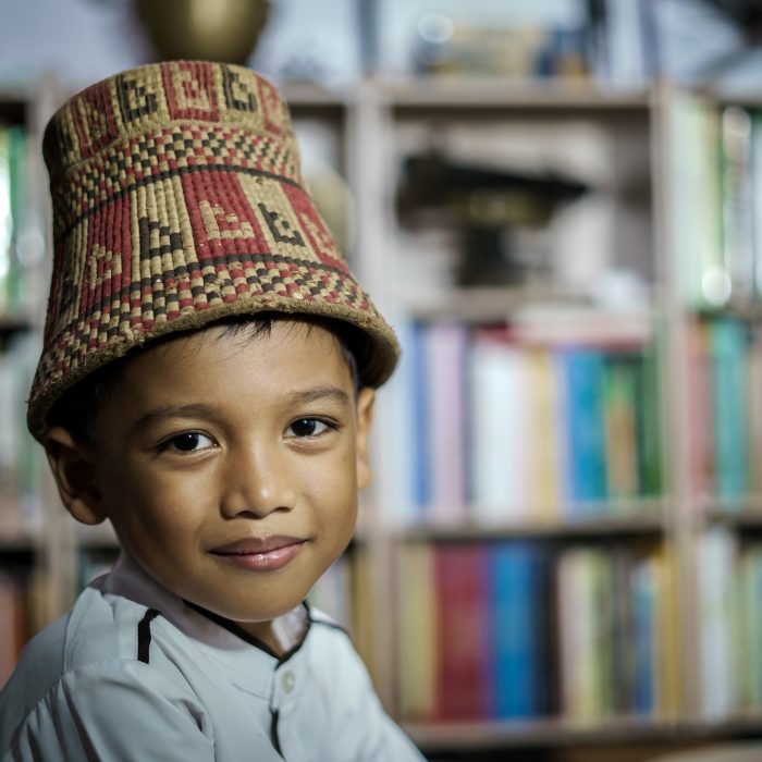 Smiling Asian boy wearing traditional skullcap of Aceh, Indonesia Smiling Asian boy wearing traditional skullcap of Aceh, Indonesia